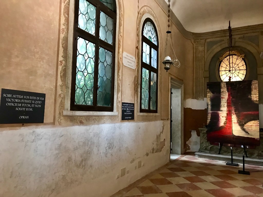 Installation view — Altar: The altar alcove at Processional: painting, inscription, and the weathered fabric of Venice held in one frame.
